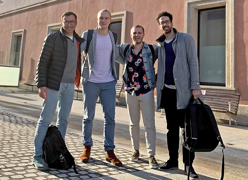 Group photo of the team outside the entrance of Universitat Pompeu Fabra